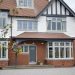 Three-story Tudor-style home with red brick and white stucco exterior, featuring large bay windows in agate grey - New Look Double Glazing